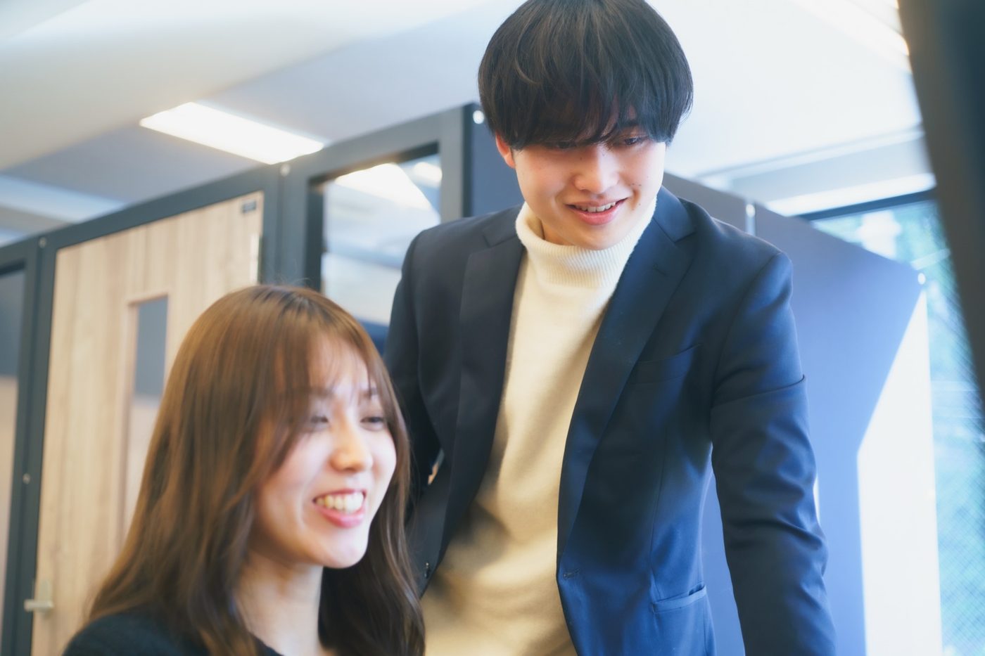 先輩社員に相談しながら作業する社員