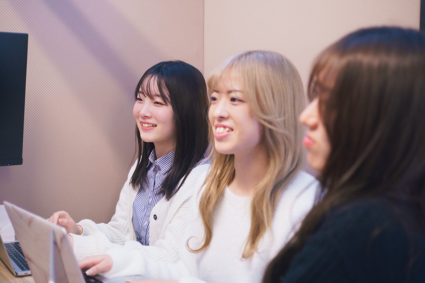 並んで笑いながら作業する女性社員たち